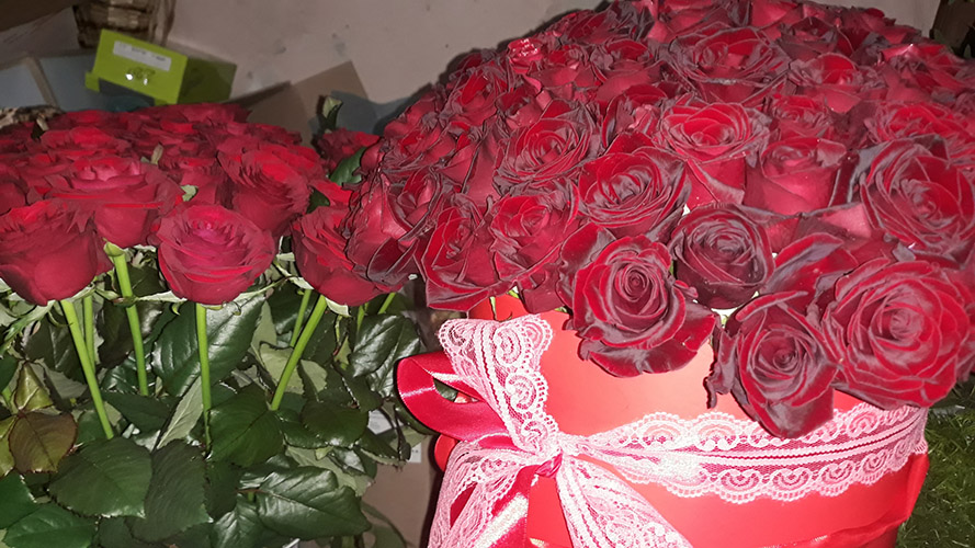 червоні троянди в букеті та коробці фото
